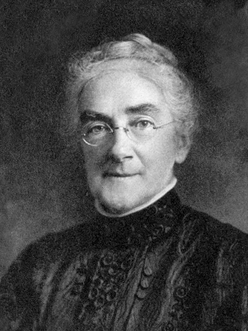 Black and white photograph of Richards, portrait, with grey hair in bun, glasses, and slight smile.